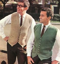 two men standing next to each other wearing sweater vests and ties, both smiling