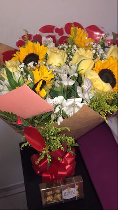 a bouquet of sunflowers and other flowers in a box