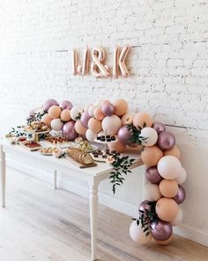 a white table topped with lots of balloons next to a sign that says k & k