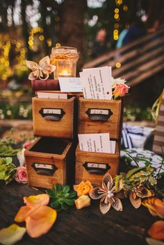 several wooden boxes stacked on top of each other with cards in them and flowers around the edges