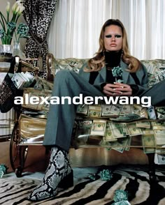 a woman is sitting on a couch with money in her hand and wearing high heels