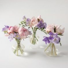 three vases filled with different types of flowers