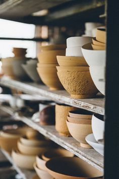 many bowls are lined up on the shelves