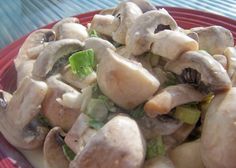 a red plate topped with mushrooms and broccoli on top of a blue table