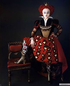 a woman in a red and black dress sitting on a chair