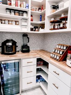 a kitchen with white cabinets and shelves filled with spices