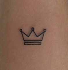 a small crown tattoo on the ankle