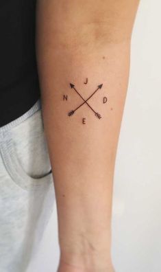 an arrow tattoo on the left arm with words and arrows written in cursive writing