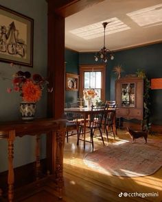 a dining room with blue walls and wooden floors