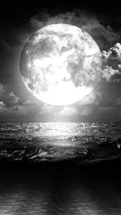 the full moon is shining over the ocean and waves in black and white photo with dramatic clouds