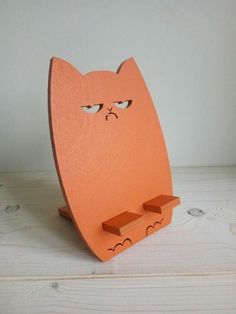 an orange wooden toy with a face drawn on it's back and eyes open