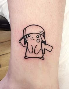 a small tattoo on the ankle of a person wearing a hat and holding a sign