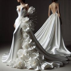 two mannequins dressed in wedding gowns with flowers on the skirt and back