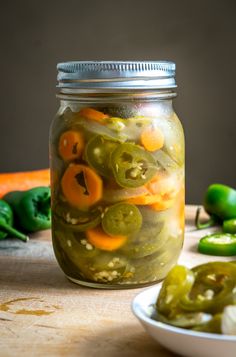 pickles and peppers in a jar on a table