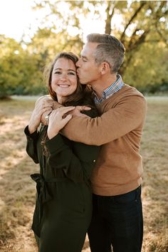 a man and woman embracing each other in an open field