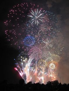 fireworks are lit up in the night sky with many different colors and shapes on display