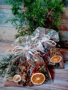 two bags filled with oranges and nuts sitting on top of a wooden table next to some branches