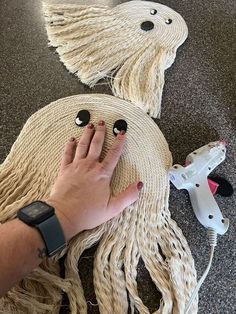 someone is making an octopus rug out of yarn and buttons on the floor next to a hair dryer