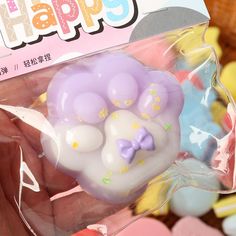 a hand holding a plastic toy in front of a package with the words happy on it