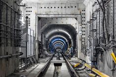 a train track going through a tunnel with lots of wires