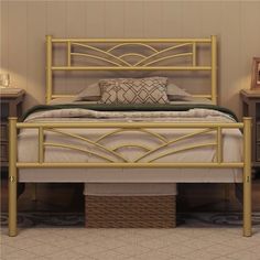 a gold metal bed frame with pillows on top of it and two night stands next to it