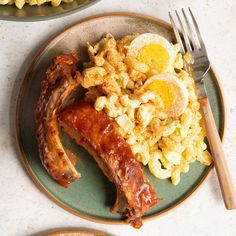 a plate with bacon, eggs and macaroni on it next to a fork