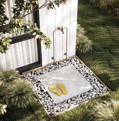 a pair of yellow flip flops sitting on top of a stepping stone in the grass