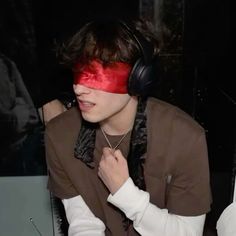 a young man wearing headphones sitting in front of a laptop computer