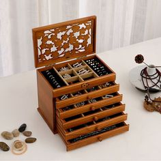 a wooden jewelry box sitting on top of a table next to rocks and other items