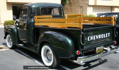 an old pickup truck parked in a parking lot