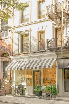 a store front with an awning on the outside and stairs to the second floor