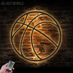 a person holding a cell phone in front of a wall with a basketball on it