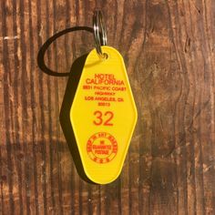 a yellow hotel keychain with the number 32 on it sitting on a wooden surface