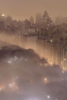 fog covers the city skyline as it sits on top of a hill