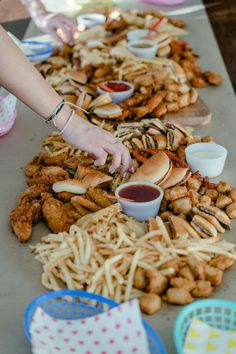 a person reaching for some food on a table