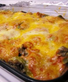 a casserole dish with meat, cheese and vegetables in it sitting on the stove