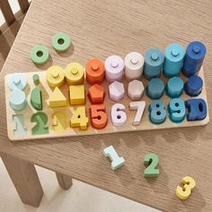 an assortment of wooden numbers and shapes on a table