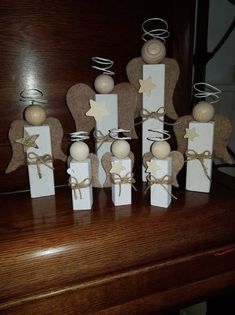 small wooden angel figurines are sitting on top of a piano with twine bows