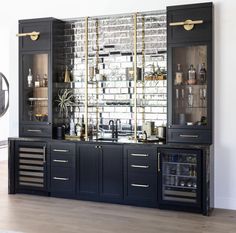 a black and gold bar with lots of bottles on it's glass front cabinets