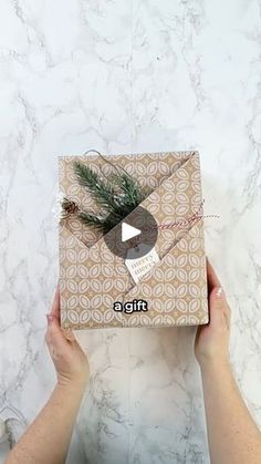 someone holding up a gift wrapped in brown paper