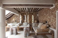 a living room filled with furniture and stone walls