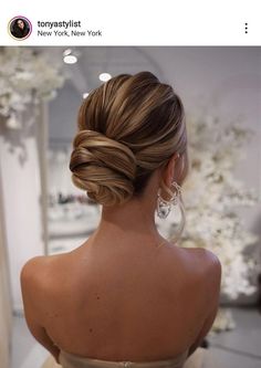 the back of a woman's head, with her hair in a low bun