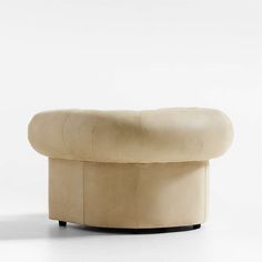 an ottoman that is made out of leather and has a curved seat on the back