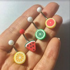 a person is holding some fruit pins in their hand