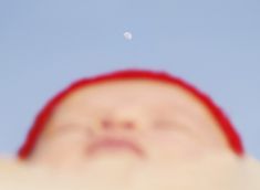 a blurry photo of a person's face with the moon in the background