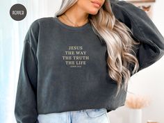 "Jesus Sweatshirt - Jesus The Way, The Truth, The Life - John 14:6  Crafted with comfort in mind, this Christian sweatshirt is made from high-quality fabric, ensuring a cozy and warm experience. The design features the profound scripture, \"Jesus The Way The Truth The Life - John 14:6,\" a constant reminder of the unwavering path to salvation. 👚Premium Quality Sweatshirts: Designs are printed on Comfort Colors 1516 sweatshirts. Comfort Colors sweaters are premium quality sweaters and designed w Jesus Sweater, Cozy Essentials, Cursive Text, Christian Sweaters, Jesus Sweatshirts, Comfort Colors Sweatshirt, Christian Sweatshirt, Bride Shirts, Sweatshirt Designs