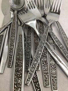 a pile of silverware sitting next to each other on top of a white table