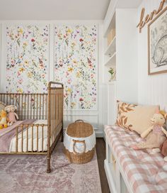 a baby's room is decorated with floral wallpaper