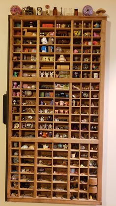 a wooden shelf filled with lots of different types of figurines on top of it