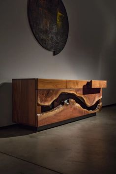 a large wooden cabinet sitting inside of a room next to a painting on the wall